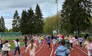 En gruppe mennesker som løper på en bane skoleløp