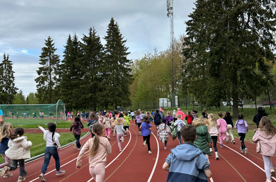 En gruppe mennesker som løper på en bane skoleløp
