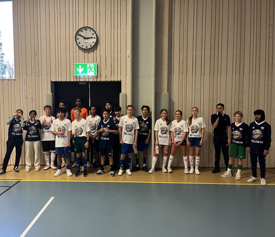 En gruppe mennesker i uniform som står i kø i en gymsal.