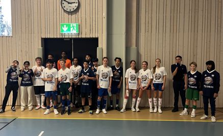 Foto: Lambertseter skole En gruppe mennesker i uniform som står i kø i en gymsal.