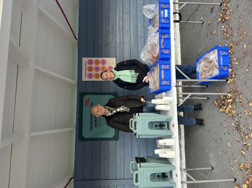 en gruppe mennesker som står på et fortau