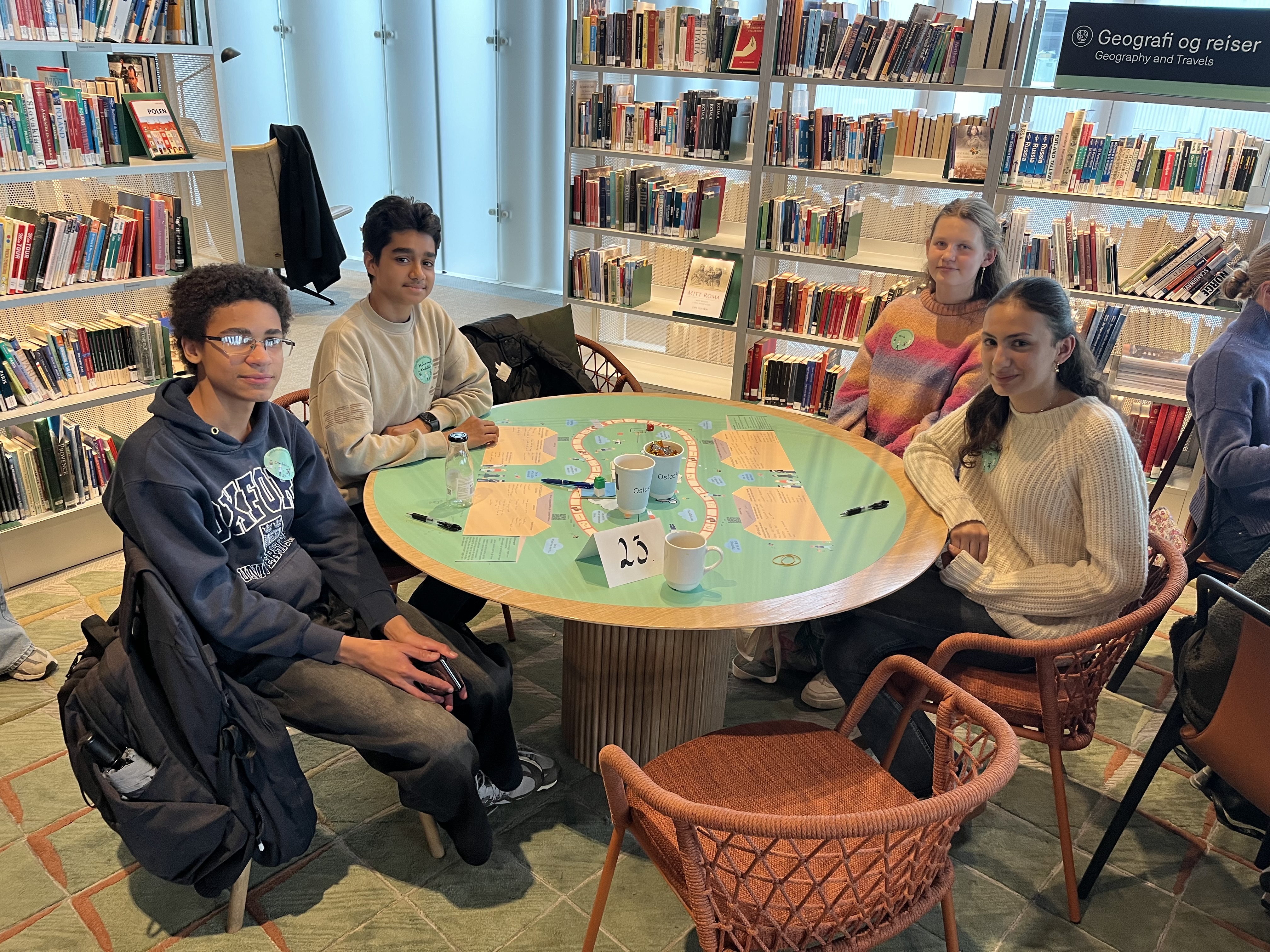 en gruppe mennesker som sitter rundt et bord i et bibliotek