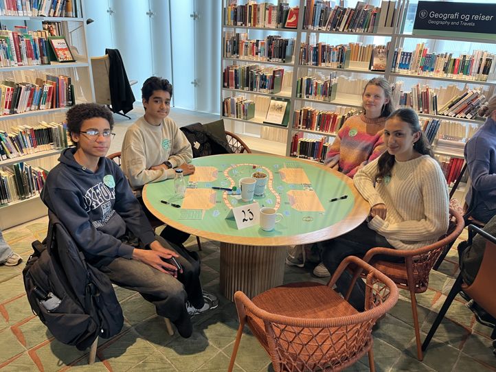 en gruppe mennesker som sitter rundt et bord i et bibliotek