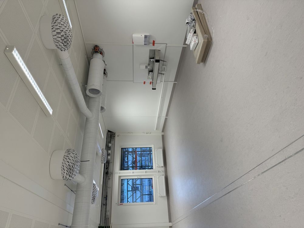 et rom med hvitt gulv og hvite vegger og et bord med gjenstander på